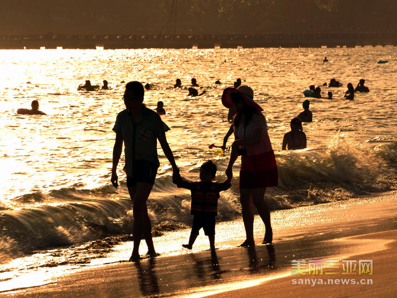 12月27日，一家三口在三亚海边戏水玩耍。