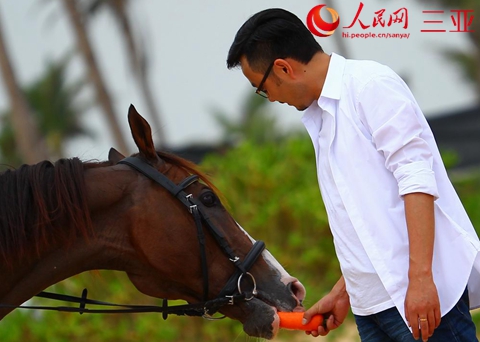 湖南卫视著名主持人汪涵在香水君澜酒店内用胡萝卜喂食骏马。