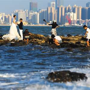 新人们在海口市西海岸的礁石上拍摄浪漫婚纱照