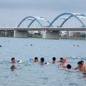 南渡江琼州大桥下近百人游泳消暑 警方:要不得