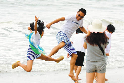 游客在三亚湾海边游玩